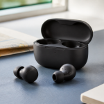 Unbranded true wireless earbuds and an open charging case on a quiet desk