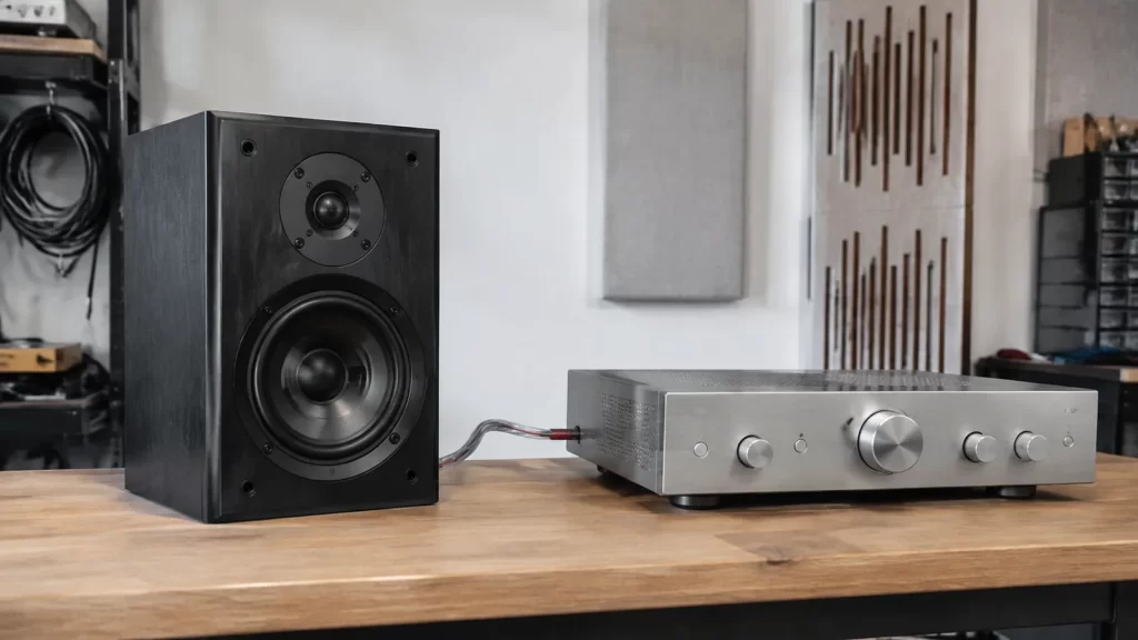 Passive bookshelf speaker and integrated amplifier connected on a clean audio test bench
